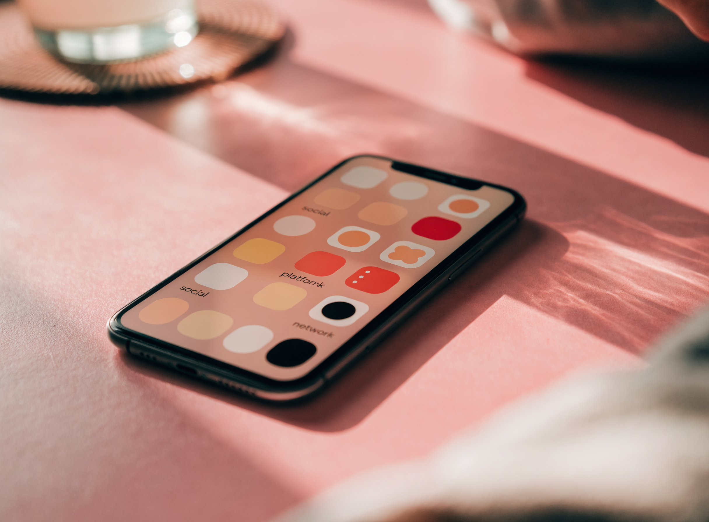 Smartphone mit Grid aus Social-Media- und Creator-Plattform-App-Icons in Rosé-Ton — Multi-Platform-Strategie von Candy Creator Agency.