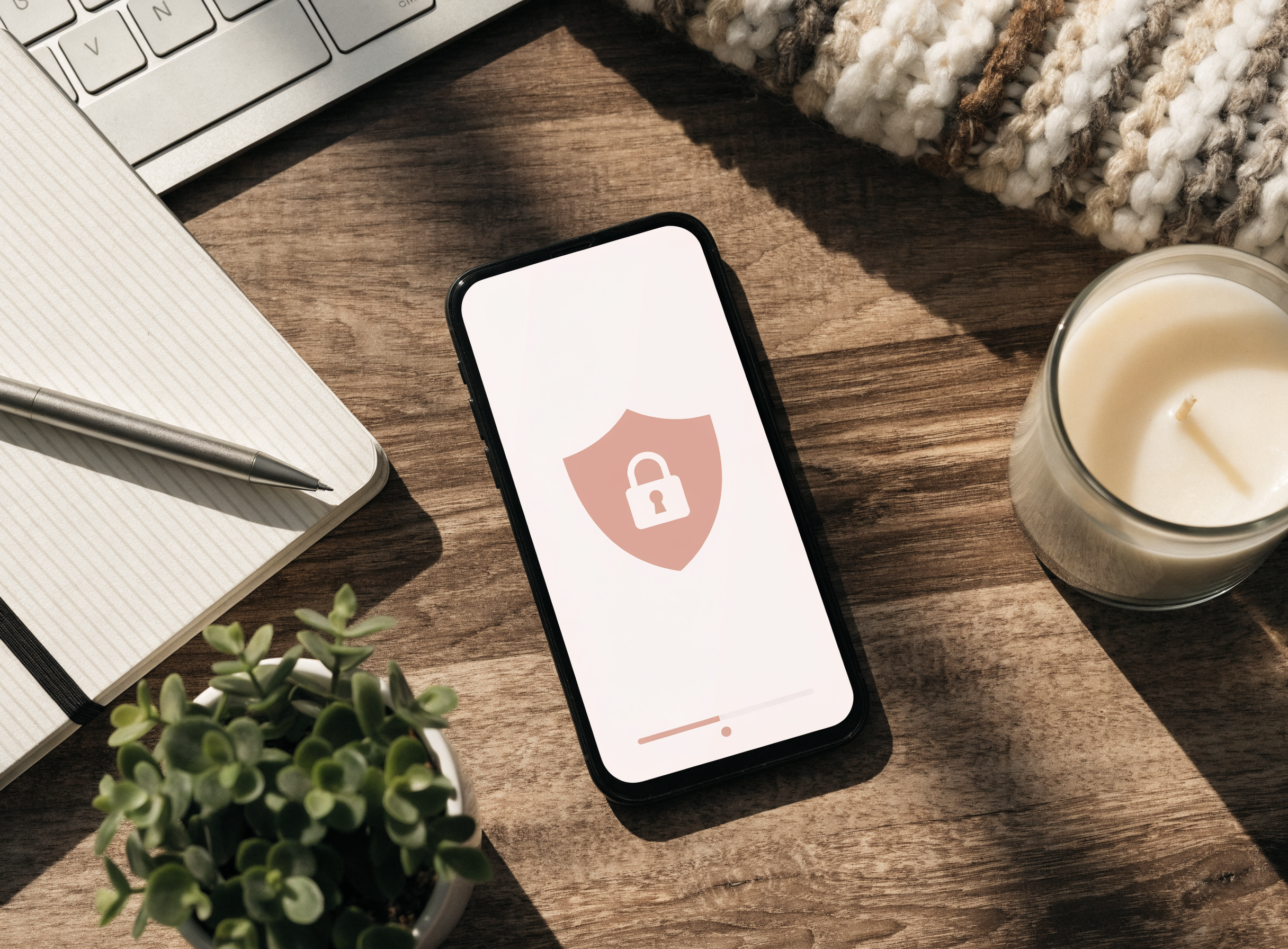 Rosé-farbenes Titelbild mit Smartphone, Schloss- und Sicherheits-Motiv auf Holztisch — Ratgeber OnlyFans Sicherheit von Candy Creator Agency.