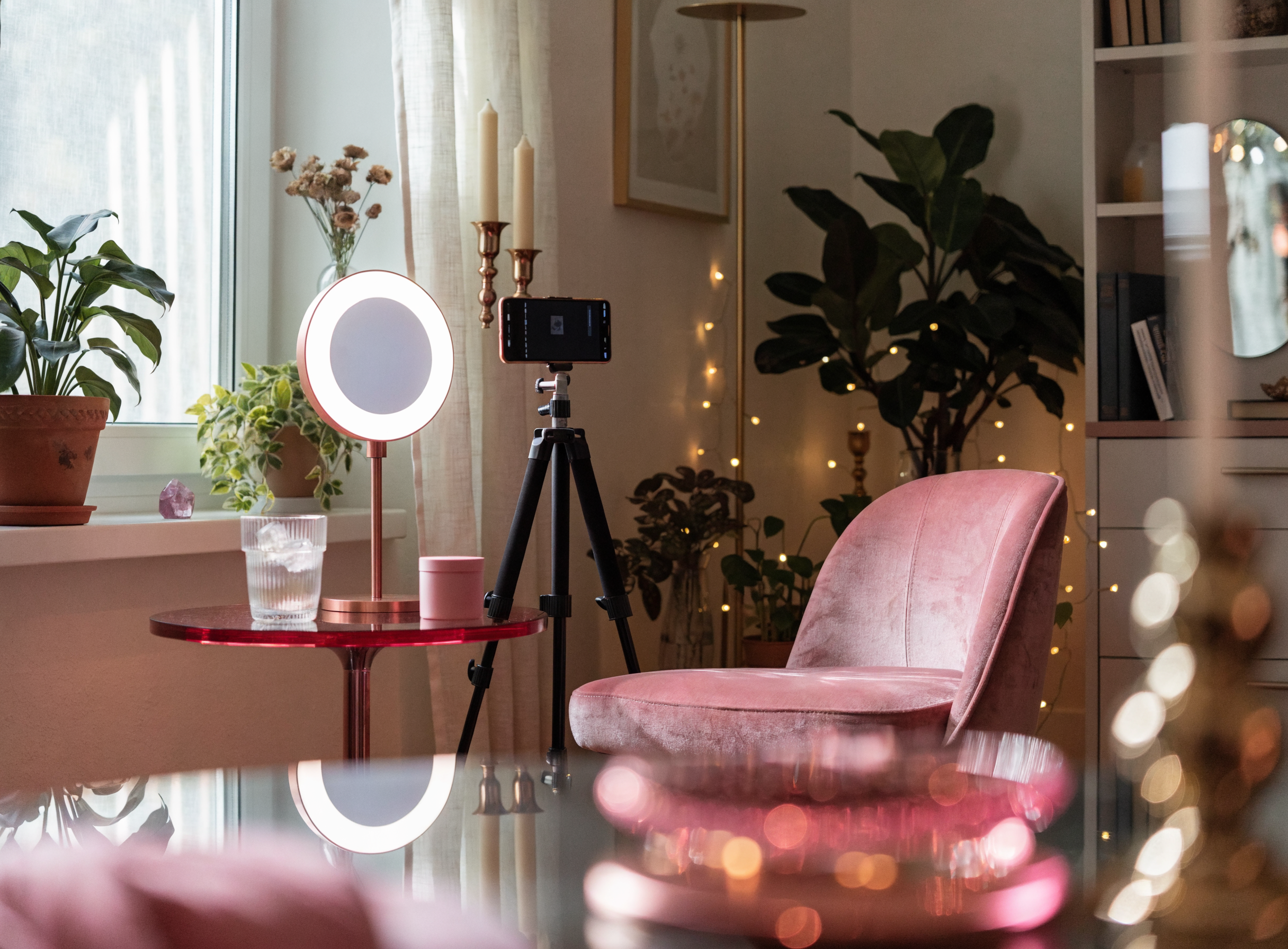 Gemütliche Content-Studio-Ecke mit rosé Sessel, Ringlicht und Pflanzen — Arbeitsumgebung eines Candy-Creator-Chatters.